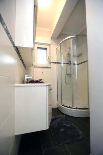 a bathroom with a glass shower with a rug at Villa Verica in Vodice