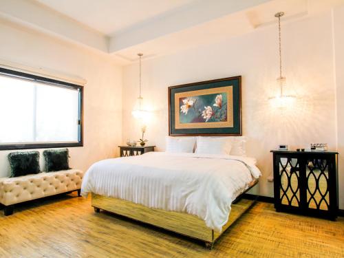 エルモシージョにあるHotel Boutique Villa Toscanaの大きなベッドと窓のある寝室