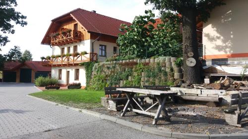 a picnic table next to a tree in front of a house at Apartmány U Srdce Vltavy in Horní Planá