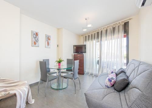 ein Wohnzimmer mit einem Sofa und einem Tisch in der Unterkunft Apart-rent Apartamento Mimoses 0063 in Empuriabrava