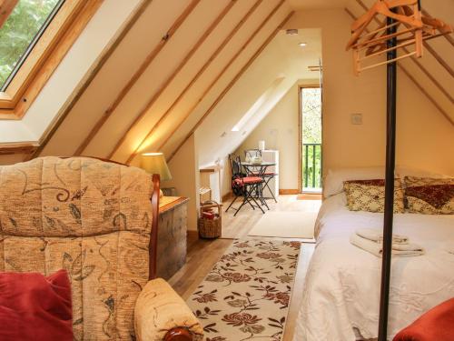 a attic bedroom with a bed and a couch at Milford Tree Tops in Craven Arms