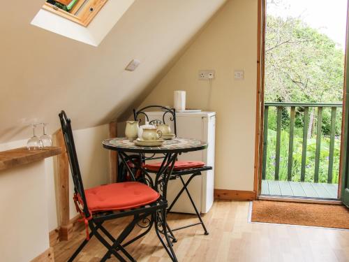 una pequeña cocina con mesa, sillas y ventana en Milford Tree Tops, en Craven Arms