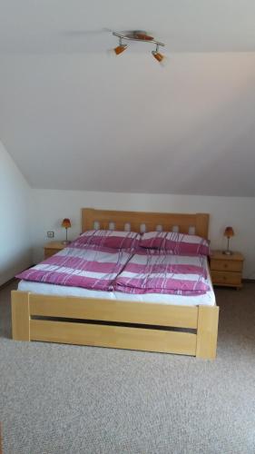 a bedroom with a bed with a pink comforter at Apartmány U Srdce Vltavy in Horní Planá