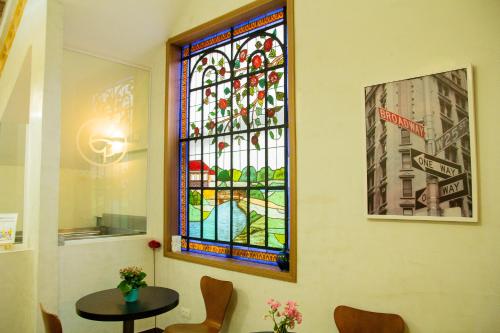 a stained glass window in a room with a table at Hotel Estação Paraíso - ao lado do Metrô Paraíso e 600m da Av Paulista in Sao Paulo