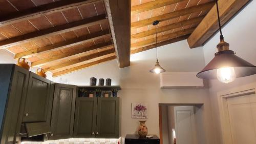 a kitchen with green cabinets and two pendant lights at Appartamenti Tinacci in San Gimignano