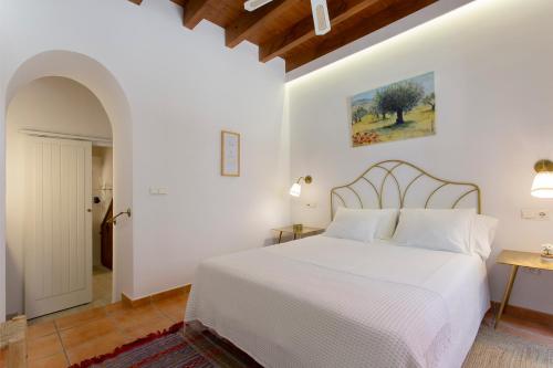 a white bedroom with a white bed and a table at La Morada Mas Hermosa in Marbella
