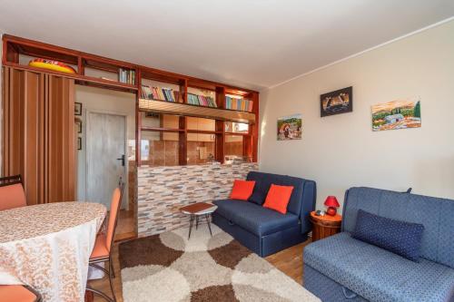 a living room with two blue chairs and a table at Apartments Pod Lozom with Seaview in Petrovac na Moru