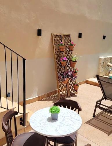 a patio with a table and chairs and potted plants at Casal de Petra - Rooms & Pool by My Rooms Hotels TI in Petra