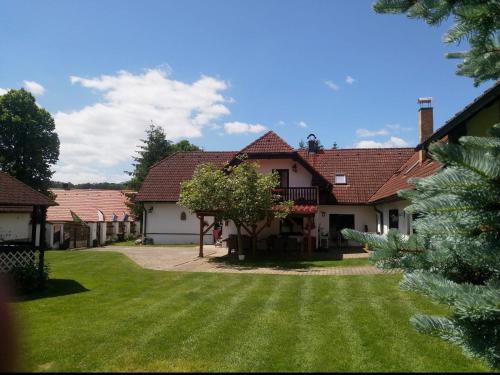 a house with a yard with green grass at Camping & Guest House Pliskovice in Mirovice