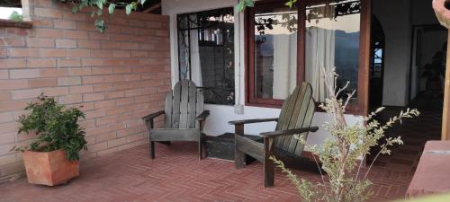 two chairs sitting on the porch of a house at Hotel Villa Palosanto in Jericó