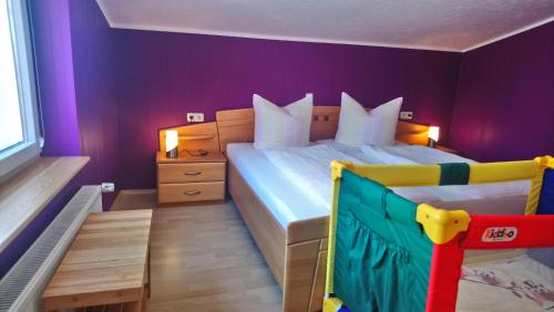 a bedroom with a large bed with purple walls at Neukalener Stadthaus Zum Alten Schmied in Neukalen