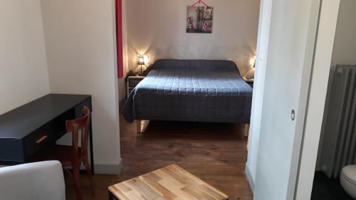 Dormitorio pequeño con cama y mesa en Le Relais de Boralde, en Espalion