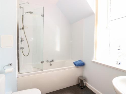 ein weißes Bad mit einer Dusche und einer Badewanne in der Unterkunft Tammie Norrie Cottage in Banff