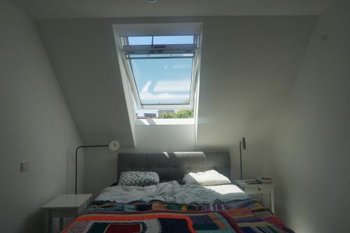 a bedroom with a bed with a window above it at Augartenblick Penthaus 14 - Blick zum Riesenrad in Vienna