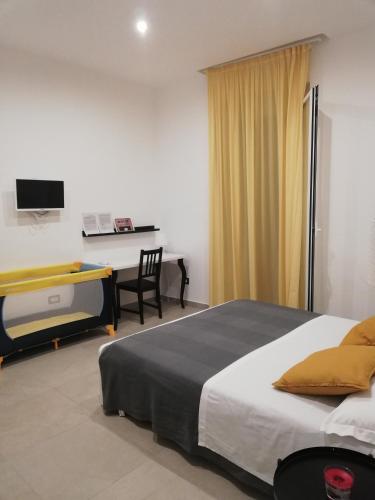a bedroom with a bed and a desk with a computer at Donna Nunzia Home in Noto