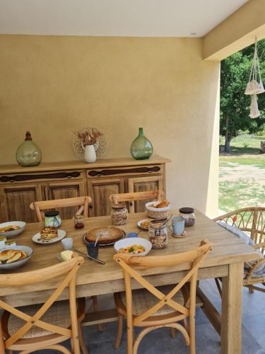 une table en bois avec des assiettes de nourriture dessus dans l'établissement Chambres d'hôte Casprese, à Altiani