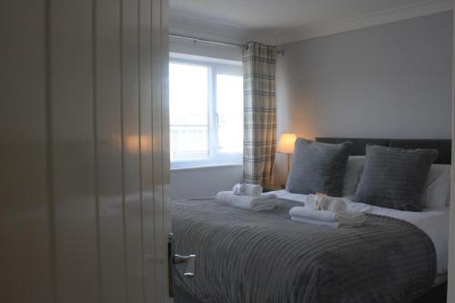 a bedroom with a large bed with towels on it at Heathmere -NEC, Airport, HS2, Resorts World, Workcation - Spacious quiet apartment in Birmingham