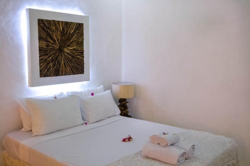 a white bedroom with a bed with towels on it at Sal Secret Spot in Uluwatu
