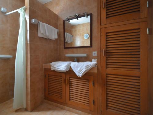 bagno con lavandino e specchio di Apartamentos Noray a Es Caló de Sant Agustí