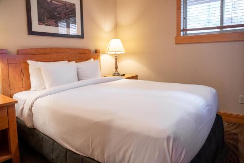 a large white bed in a hotel room at The Hidden Ridge Resort in Banff