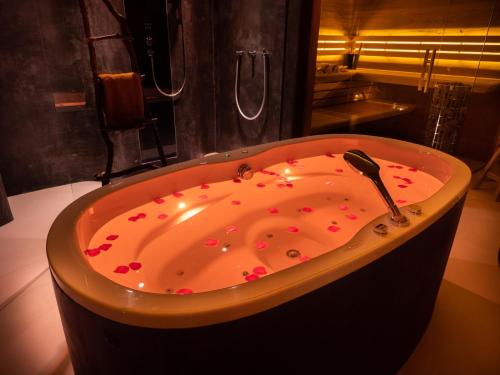 a bath tub filled with red hearts in a bathroom at Dreams and Wellness in Vorstenbosch