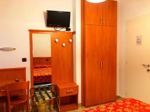 a bedroom with a wooden cabinet and a mirror at Hotel Sanmicheli in Verona
