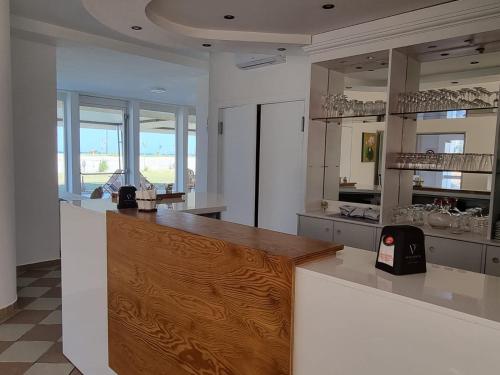a kitchen with a white counter top and wooden floors at Hotel Rivabella in Davoli