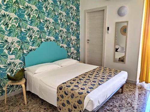 een slaapkamer met een bed en blauw en wit behang bij A Polignano Rooms in Polignano a Mare