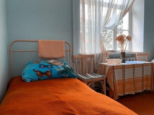 een slaapkamer met een bed met een oranje deken en een raam bij Ojakh in Dilidzjan