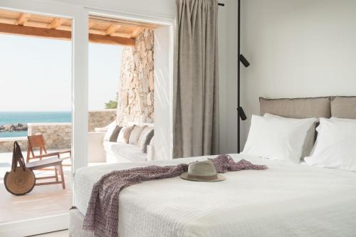 a bedroom with a bed with a hat on it at Casa Del Mar - Small Luxury Hotels of the World in Agios Ioannis Mykonos