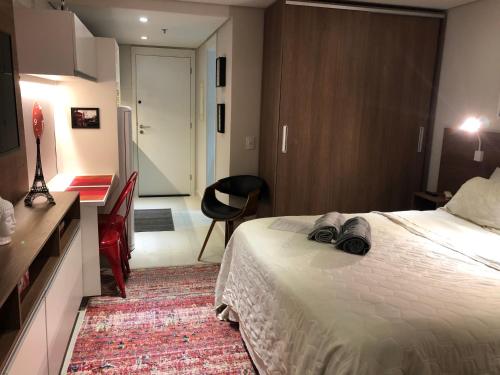 a hotel room with a bed and a desk at Flat Granja Brasil Itaipava in Petrópolis