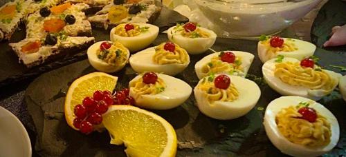 a plate of deviled eggs and fruit on a table at Meister BÄR HOTEL Fichtelgebirge in Marktredwitz