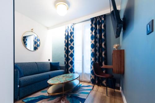 a living room with a blue couch and a table at Hotel Bleu de Grenelle - Tour Eiffel in Paris