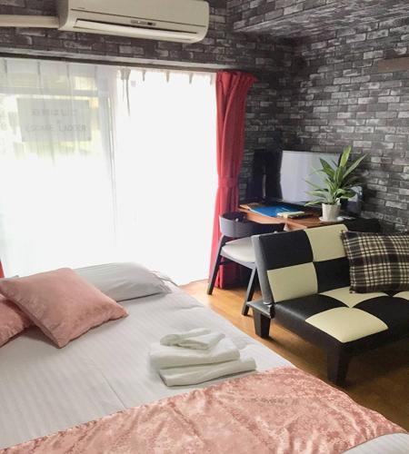 a bedroom with a bed and a chair and a desk at La Foret Fujimi - Vacation STAY 45794v in Hiroshima