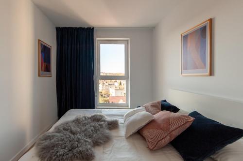 1 dormitorio con cama con almohadas y ventana en Apartament Harmony 93 en Gdynia