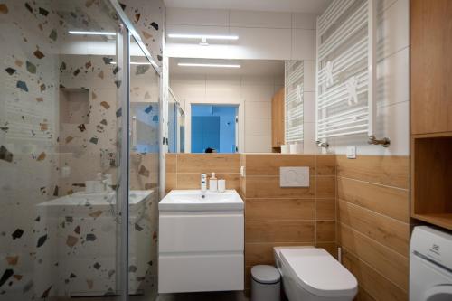 y baño con aseo, lavabo y ducha. en Apartament Harmony 93 en Gdynia