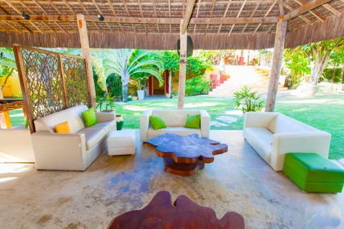 a living room with couches and a table at Hotel Aconchego Porto de Galinhas in Porto De Galinhas