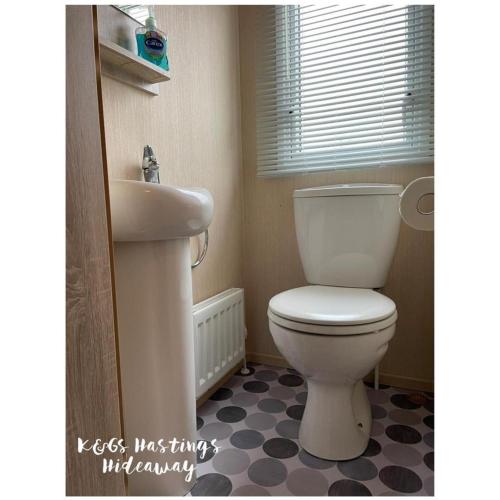 a bathroom with a white toilet and a sink at Comfortable 3-Bed Caravan - Combe Haven in Hollington