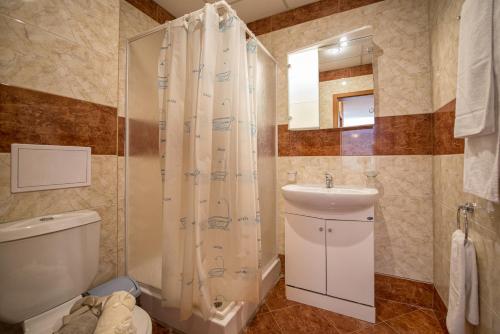 a bathroom with a shower and a toilet and a sink at Privilege Beach Apartments in Sveti Vlas