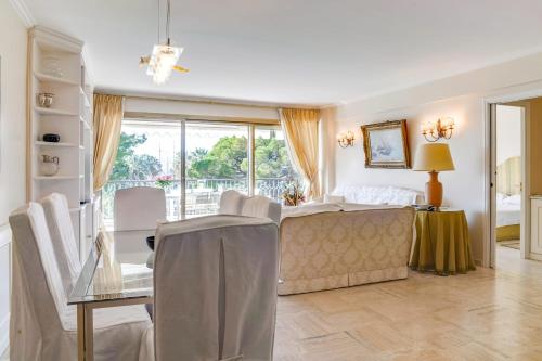 une chambre avec un lit, une table et des chaises dans l'établissement IMMOGROOm- two terraces - Sea view - CROISETTE - AC, à Cannes