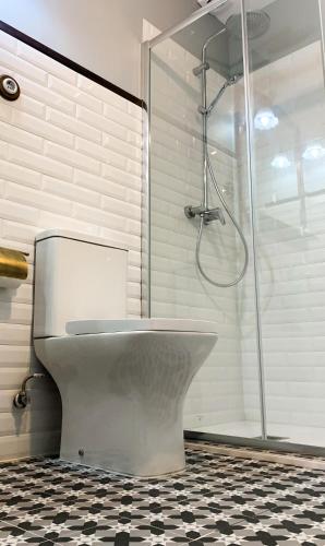 a bathroom with a shower and a toilet and a glass shower stall at La Venta de Miyares - Casa de Indianos in Piloña