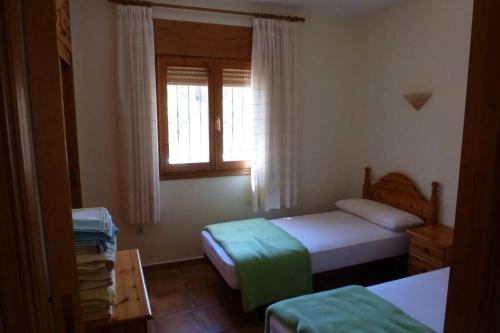 a small bedroom with two beds and a window at Casa Helena in Moraira
