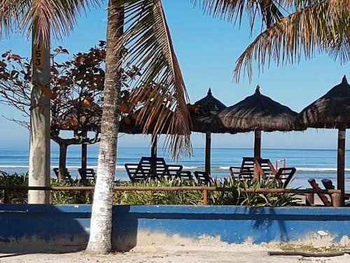 una spiaggia con sedie e ombrelloni e l'oceano di Casa de praia Boracéia a Bertioga
