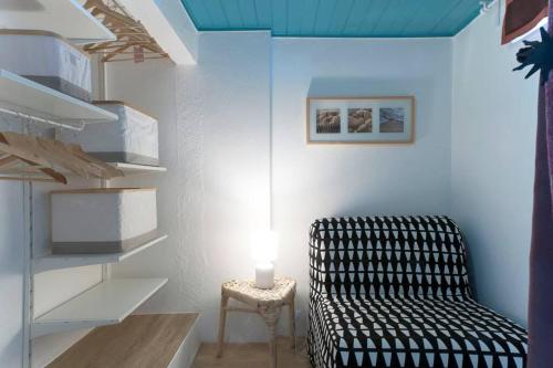 a living room with a chair and a lamp at Blue Studio Sesimbra - Com acesso privado à praia in Sesimbra
