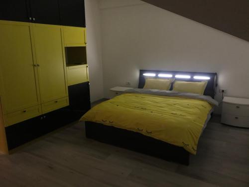 a bedroom with a yellow bed and yellow cabinets at Eli’s Apartament in Piatra Neamţ