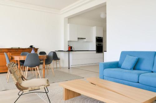 un salon avec un canapé bleu et une table dans l'établissement IMMOGROOM - SEA VIEW - 2 min from beach - CONGRESSBEACHES, à Cannes