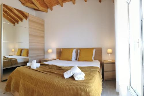 um quarto com uma cama grande e toalhas em Houses of Eira Velha em Fajã do Ouvidor