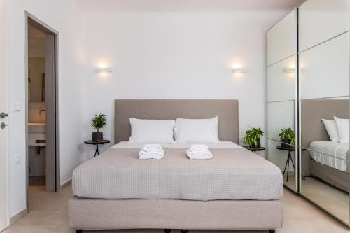 a bedroom with a large bed with two towels on it at DeKo Villa Mykonos in Ano Mera