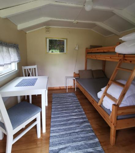 a room with bunk beds and a table and a desk at Tommerneset Camping in Innhavet