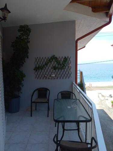 a balcony with a table and chairs on the beach at AGATHA appartments PALIOURIA in Kókkinon Nerón